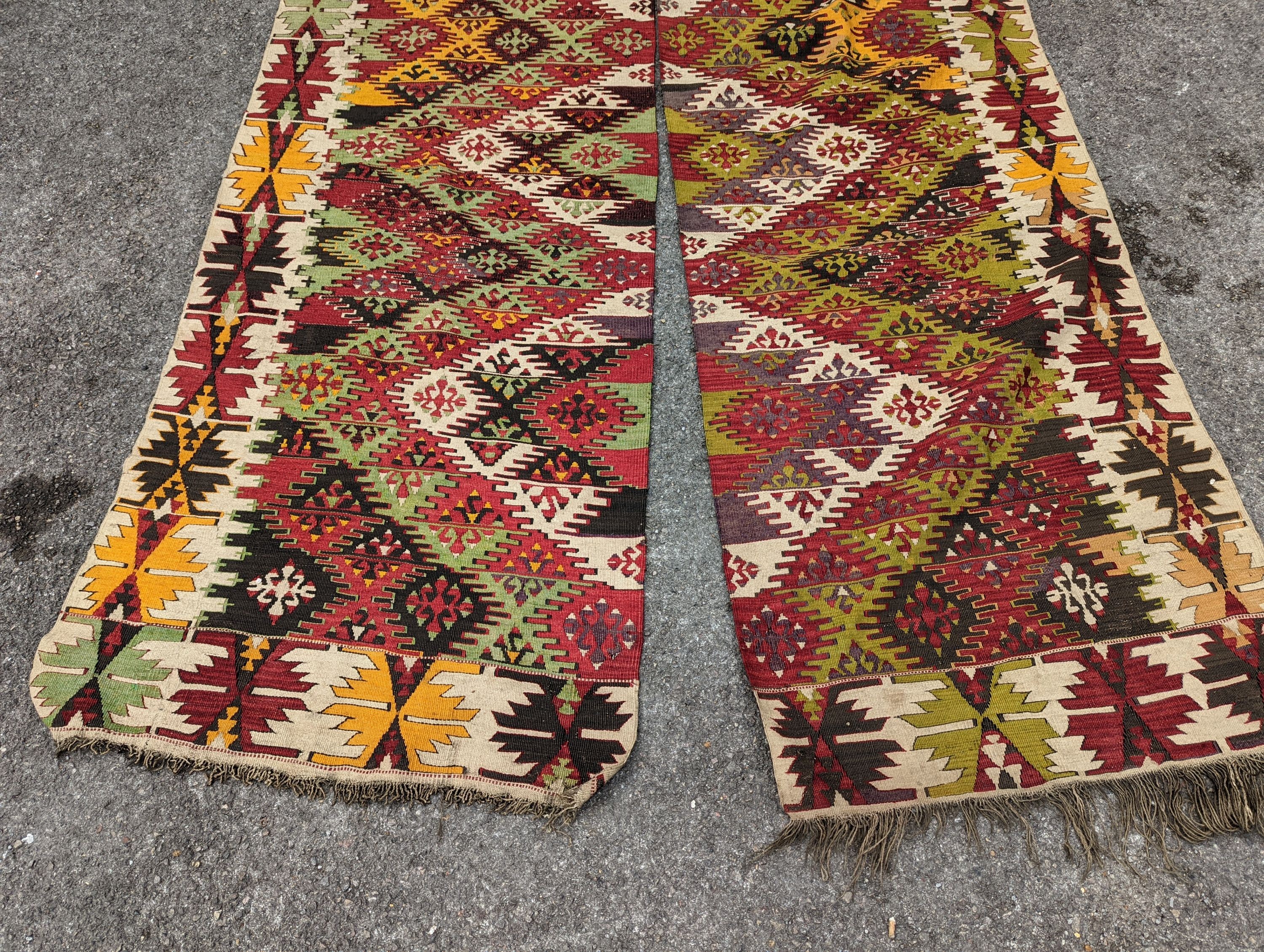 A Kelim polychrome flatweave carpet, cut centrally to create a pair of runners, each 410 x 85cm